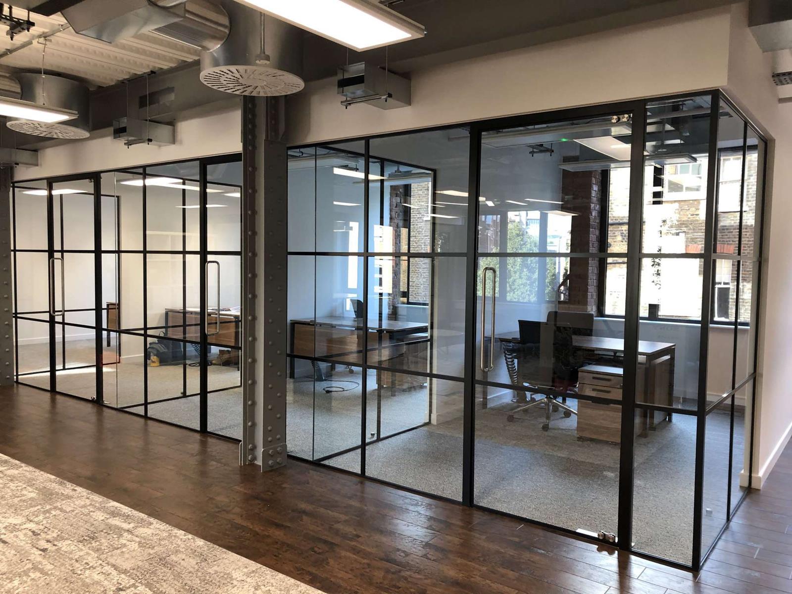 Glazed offices partitions London made of a combination of tempered glass and black steel elements